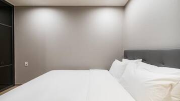 Ein modernes Schlafzimmer mit einem Bett, einer Kopfteil und einem an der Wand befestigten Regal.