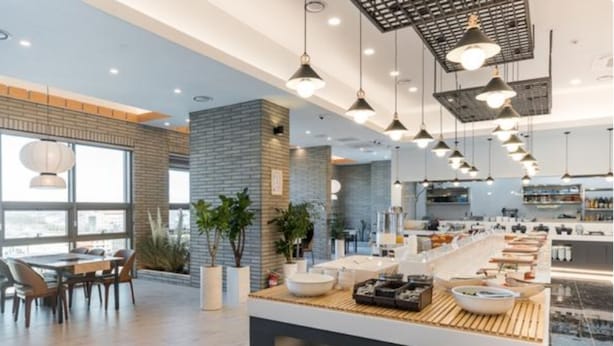 A modern kitchen with a central island, pendant lighting, and a view of the city. - Jeonju Signature Hotel (Jeonju)