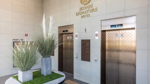 The Jeonju Signature Hotel's lobby with two elevators, a post box, and decorative plants. - Jeonju Signature Hotel (Jeonju)