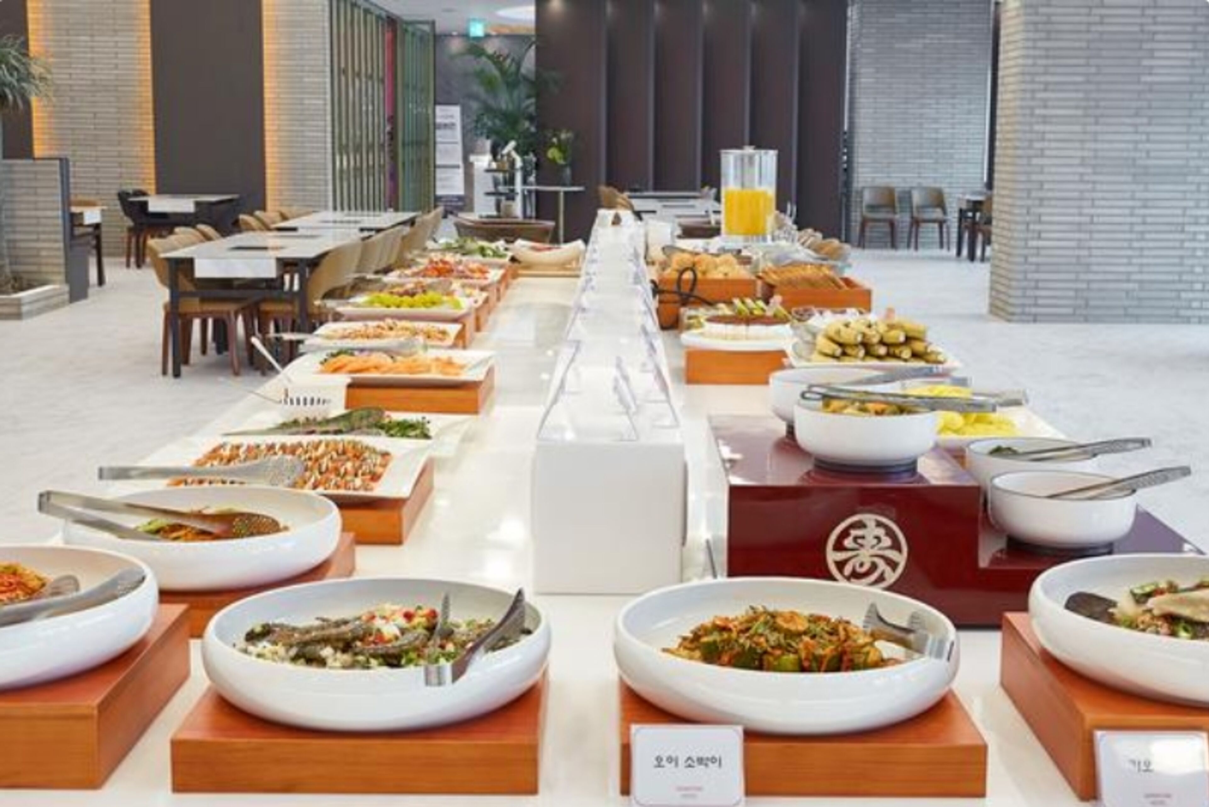 Un buffet proposant une variété de plats et un distributeur de jus.