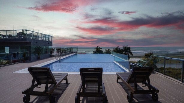 A rooftop pool with lounge chairs and a view of the ocean. - DERA Resort & Spa- Cox's Bazar (Cox's Bazar)