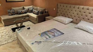 Een slaapkamer met een bed, een bank en een schilderij aan de muur.