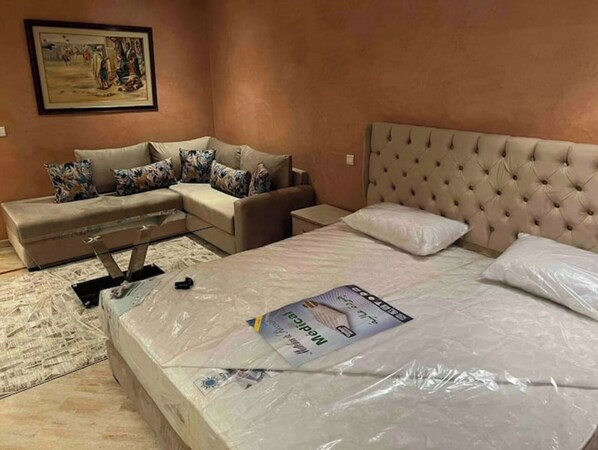 Une chambre à coucher avec un lit, un canapé et un tableau accroché au mur.