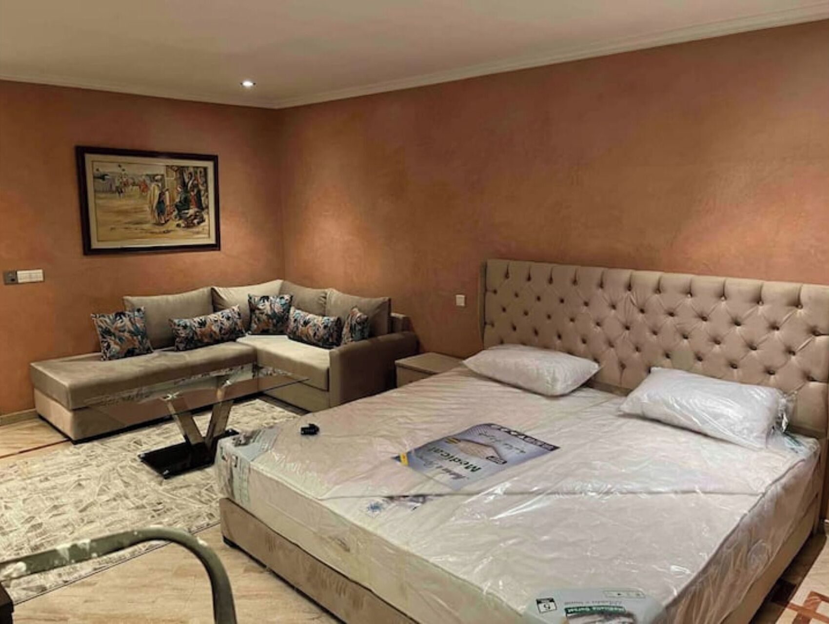 Une chambre avec un grand lit, un canapé et un tableau accroché au mur.