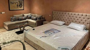 Een slaapkamer met een groot bed, een bank en een schilderij aan de muur.
