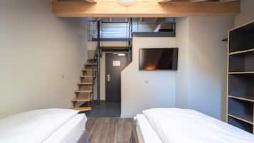 A compact room with two beds, a staircase, a built-in TV, and a wooden ceiling.