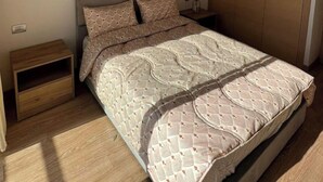 A bedroom with a bed, a nightstand, a wardrobe, and a wall-mounted artwork. - Shiny appartment in Prestigia (Rabat)