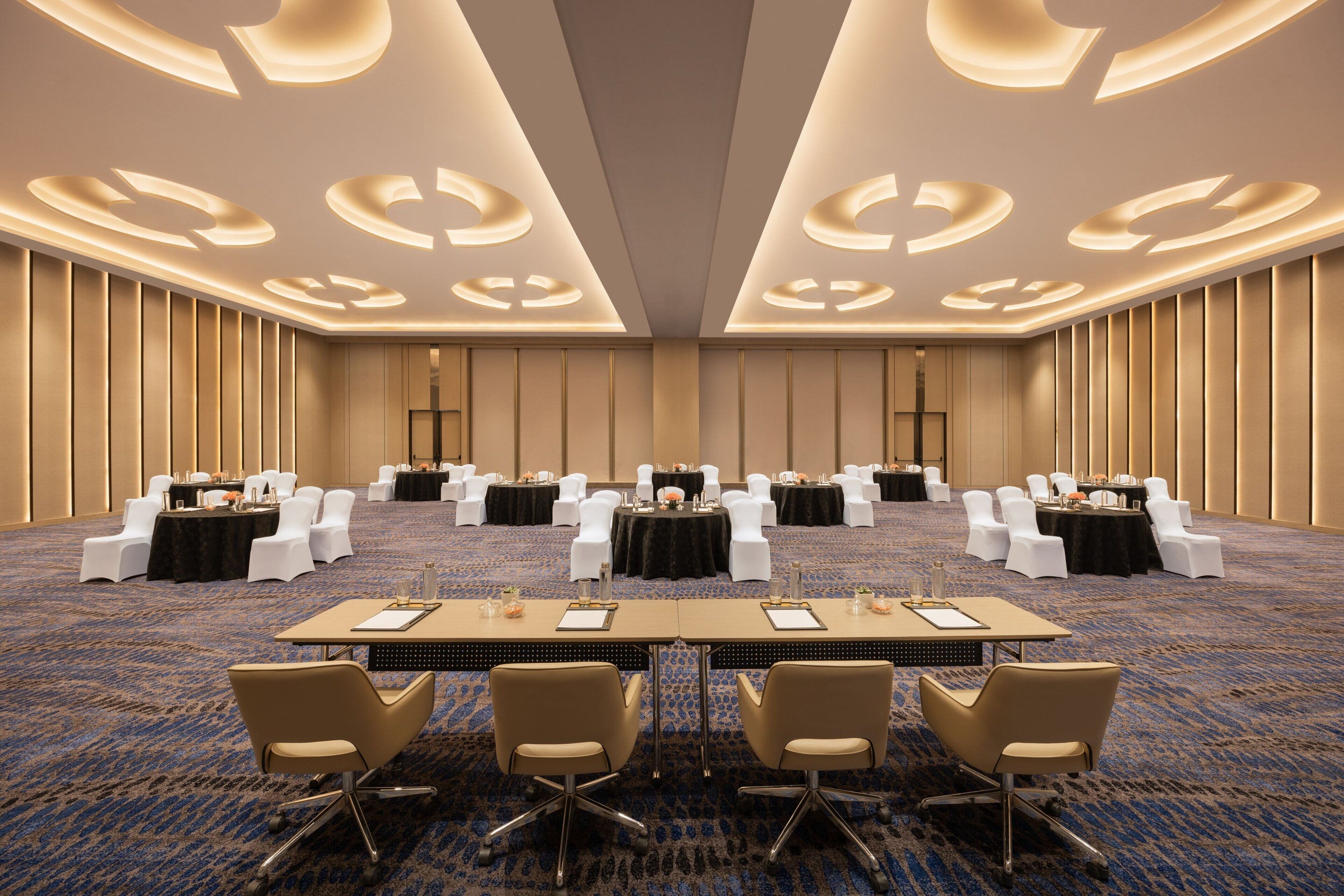 A conference room with tables, chairs, and a carpeted floor.