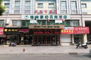 A hotel with a sign for the Green Tree Shell Hotel, a restaurant, and a 24-hour service center. - GreenTree Shell Hotel (Yiwu International Business City Changchun Accessories Specialty Street) (Yiwu)