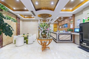 A hotel lobby with a reception desk, seating area, and a decorative centerpiece. - GreenTree Shell Hotel (Yiwu International Business City Changchun Accessories Specialty Street) (Yiwu)