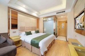 A hotel room with a large bed, a sofa, a desk, and a mirror. - GreenTree Shell Hotel (Yiwu International Business City Changchun Accessories Specialty Street) (Yiwu)