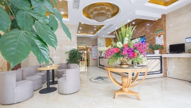 A lobby with a reception desk, seating area, and a large plant. - GreenTree Shell Hotel (Yiwu International Business City Changchun Accessories Specialty Street) (Yiwu)