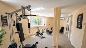 A gym with exercise equipment, a treadmill, and dumbbells. - Fiesta Garden Hotel (Bantay)