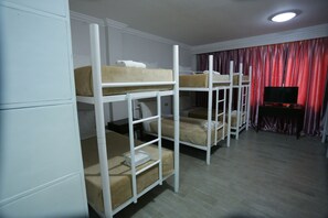 A room with bunk beds, a flat-screen TV, and a red curtain. - Fiesta Garden Hotel (Bantay)