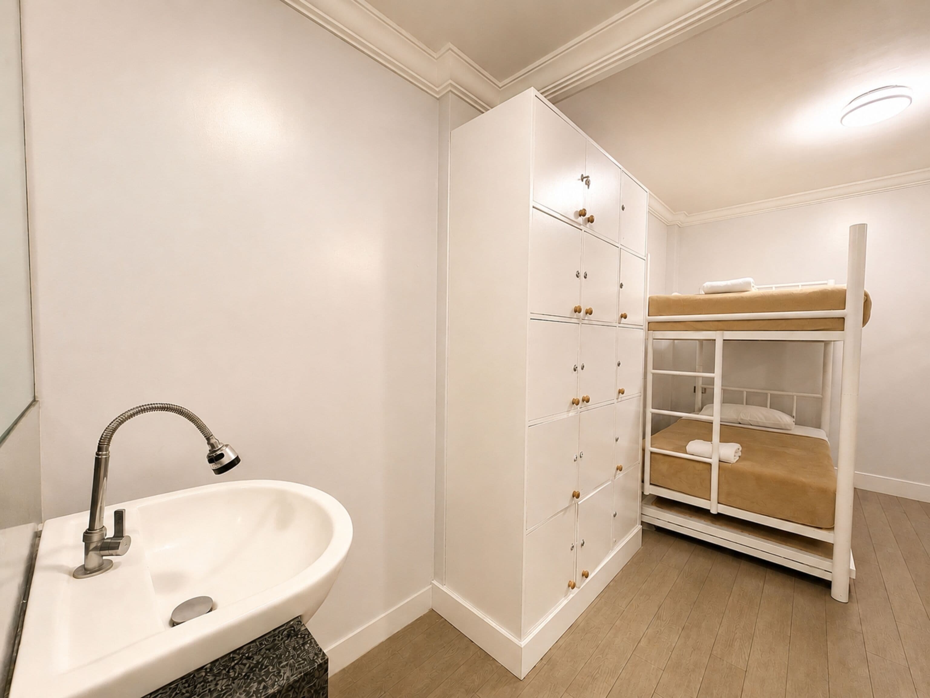Un bagno con un lavandino bianco, uno specchio e un armadio bianco con scomparti multipli.