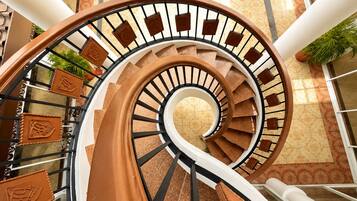Una escalera de caracol con barandilla y suelo estampado.