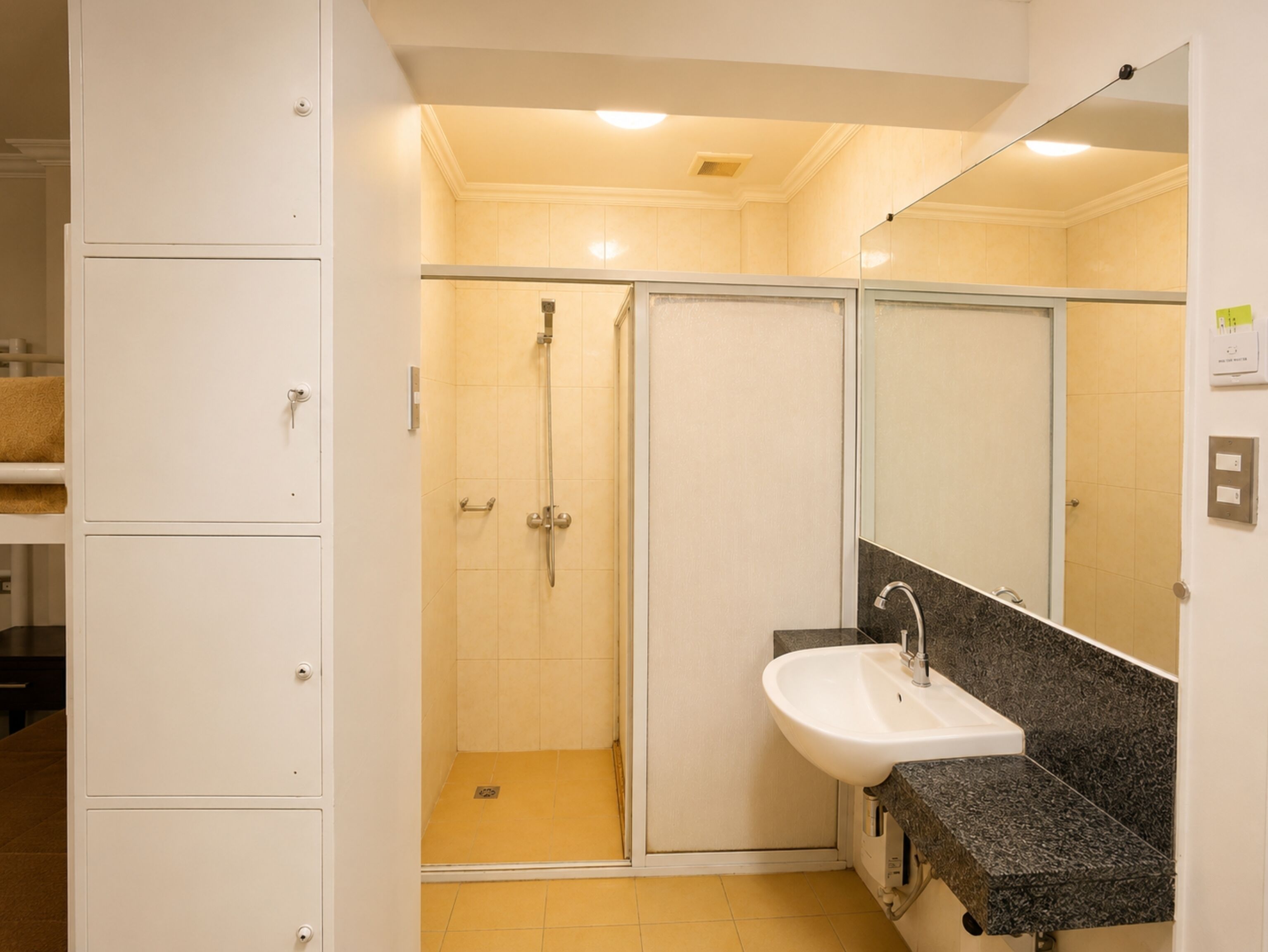 A bathroom with a shower, a sink, and cabinets.
