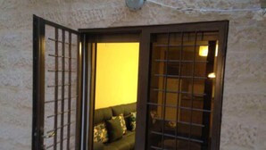 An open door leading to a room with a sofa and a wall-mounted light fixture.