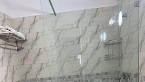 A modern bathroom with a glass-enclosed shower, a toilet, and a sink. - Cozy place in the heart of rabat (Rabat)