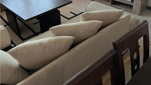A modern living room with a sofa set, a dining table, and a TV on a wooden stand. - Cozy place in the heart of rabat (Rabat)