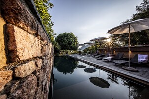 Una piscina al aire libre de temporada, sombrillas