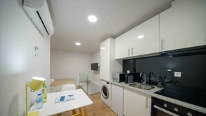 A compact kitchen with a washing machine, a microwave, and a sink.