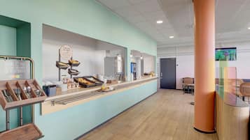 Un espace moderne et bien aménagé pour le petit-déjeuner, avec un comptoir, des sièges et une grande colonne.