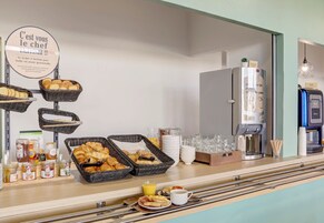 Un bufé de desayuno con diversos pasteles, pan y bebidas.