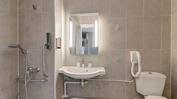 A modern bathroom with a shower, sink, and toilet.