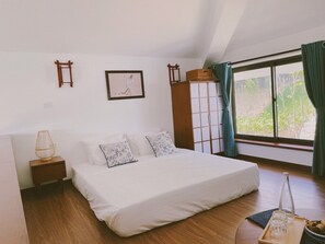 A bedroom with a large bed, a nightstand, a wardrobe, and a window with curtains. - HASU VILLAGE (Hoa Binh)