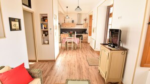 A compact living space with a kitchenette, dining area, and a television on a cabinet.