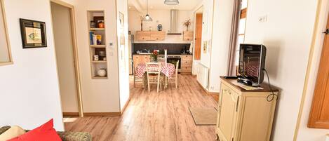 A compact living space with a kitchenette, dining area, and a television on a cabinet.