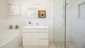 A modern bathroom with a white vanity, a glass shower enclosure, and a hexagonal tile pattern on the walls. - Coolum Beach 1 Bedroom Apartment Ocean View @ Surf Dance (Sunshine Coast)