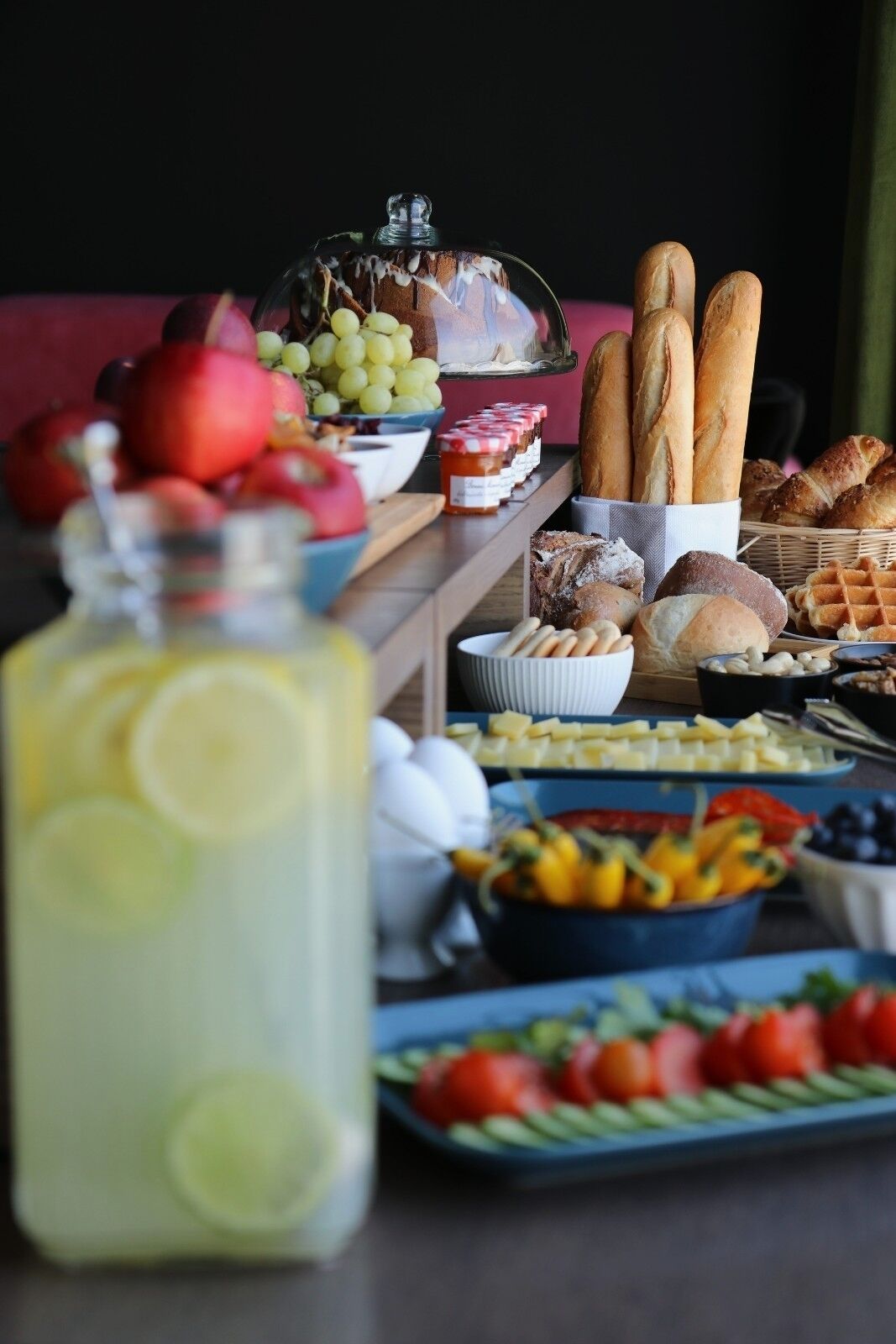 Una mesa de buffet con diversas opciones de comida, incluyendo frutas, pan y salsas.