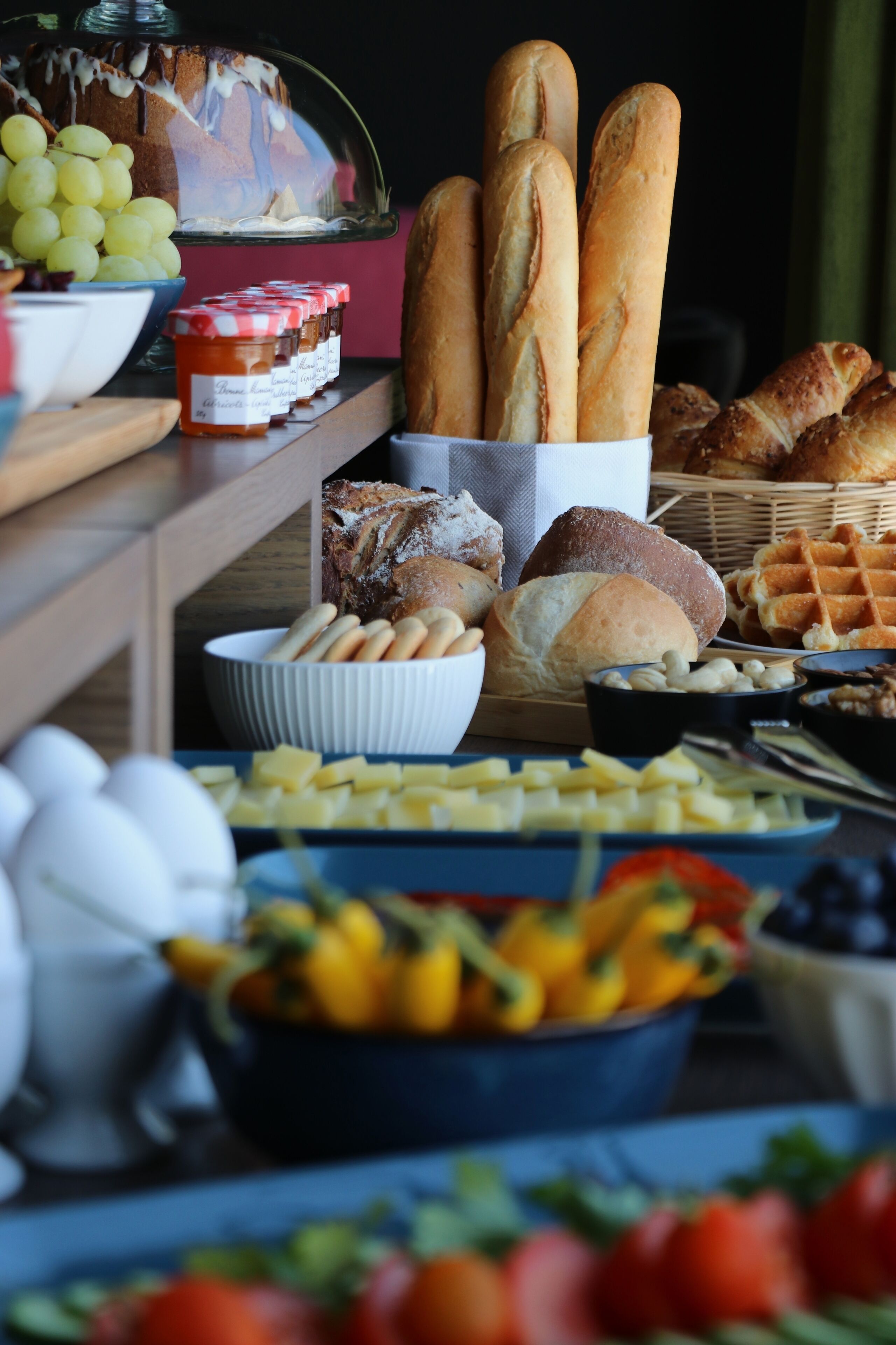 A buffet table with various food items including bread, cheese, and fruits.