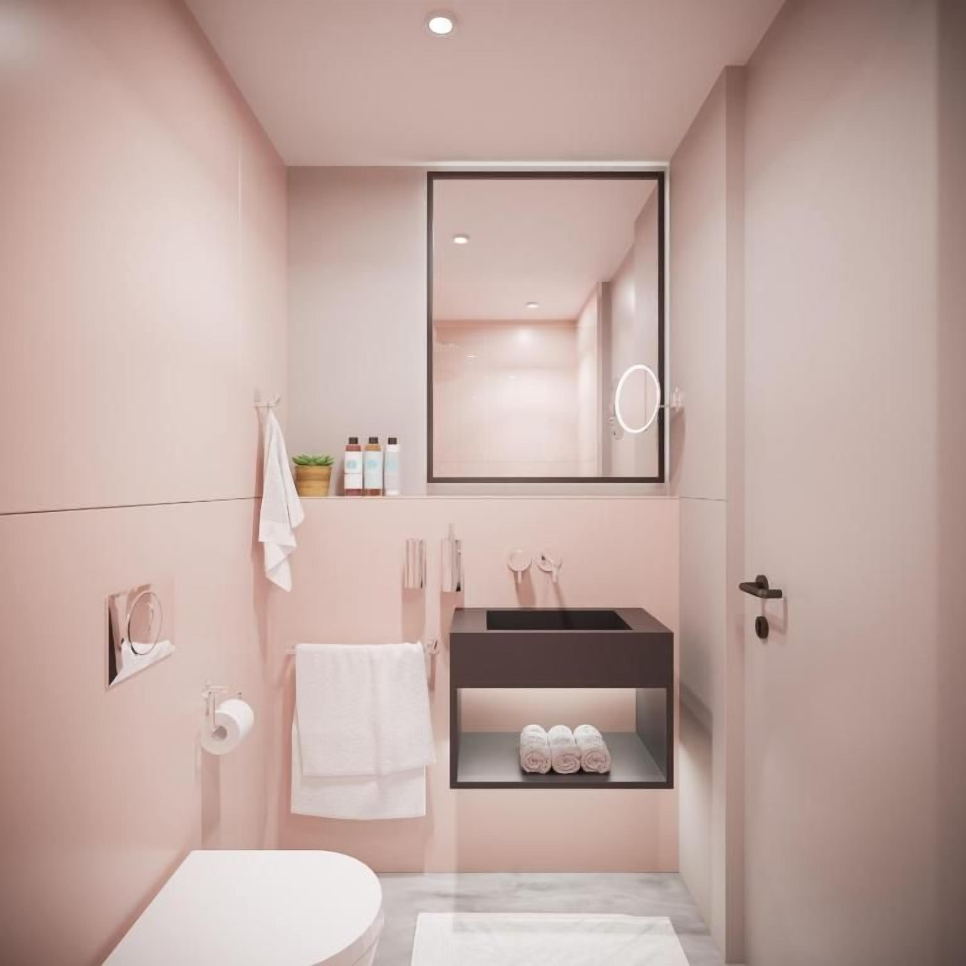A modern bathroom with a toilet, sink, and mirror.