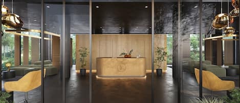 Et receptionområde med en træreception, moderne stole og store vinduer med udsigt over grønne områder.