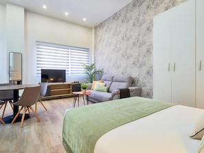 A modern bedroom with a bed, a desk, and a sofa. - Del Parque Flats Capuchinos: Cosy Studio in Historic Malaga with Double Bed & Sofa Bed (Málaga)