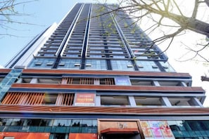 Un edificio de gran altura con varios pisos, balcones y un letrero que indica un centro de negocios.