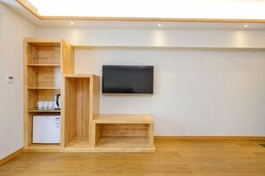 A room with a flat-screen TV mounted on the wall, wooden shelving units, and a small white appliance. - Yuexi Xiaoshe Homestay (Chongqing Guanyinqiao Hongqihegou Light Rail Station) (Chongqing)