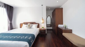 A hotel room with a bed, bedside table, lamp, wardrobe, and a bench. - Flesta Doi Can (Hanoi)