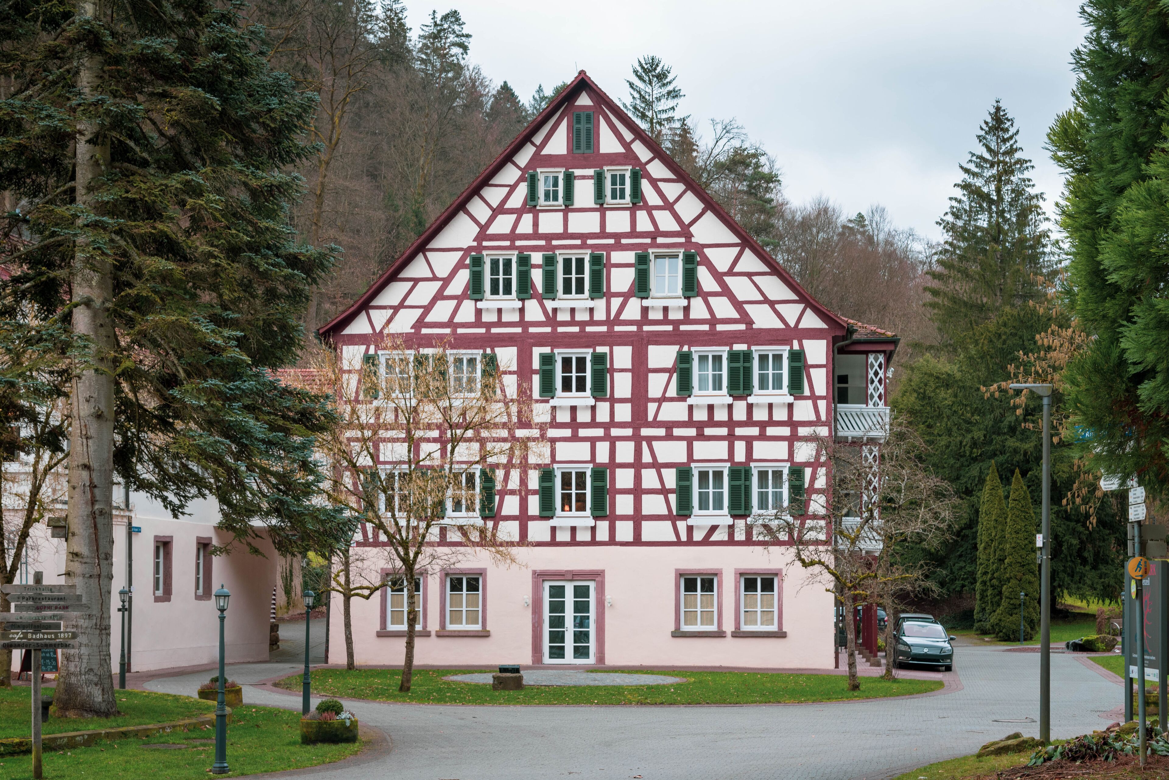 Une maison traditionnelle à colombages, dotée d’une façade symétrique, de nombreuses fenêtres et d’une entrée centrale.