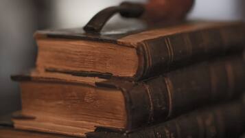 A stack of old books with a pipe on top.
