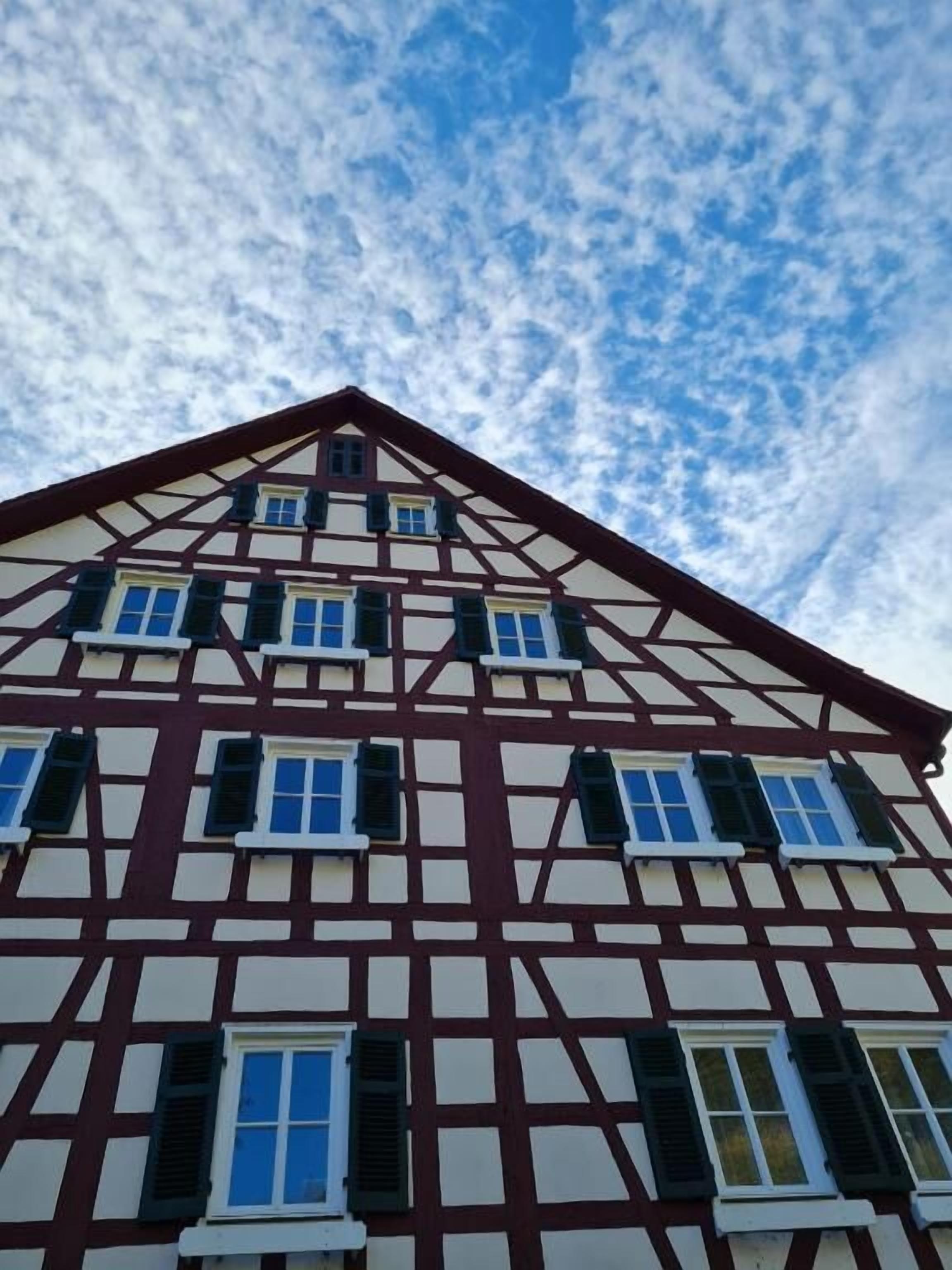 A traditional half-timbered building with multiple windows and a steeply pitched roof.