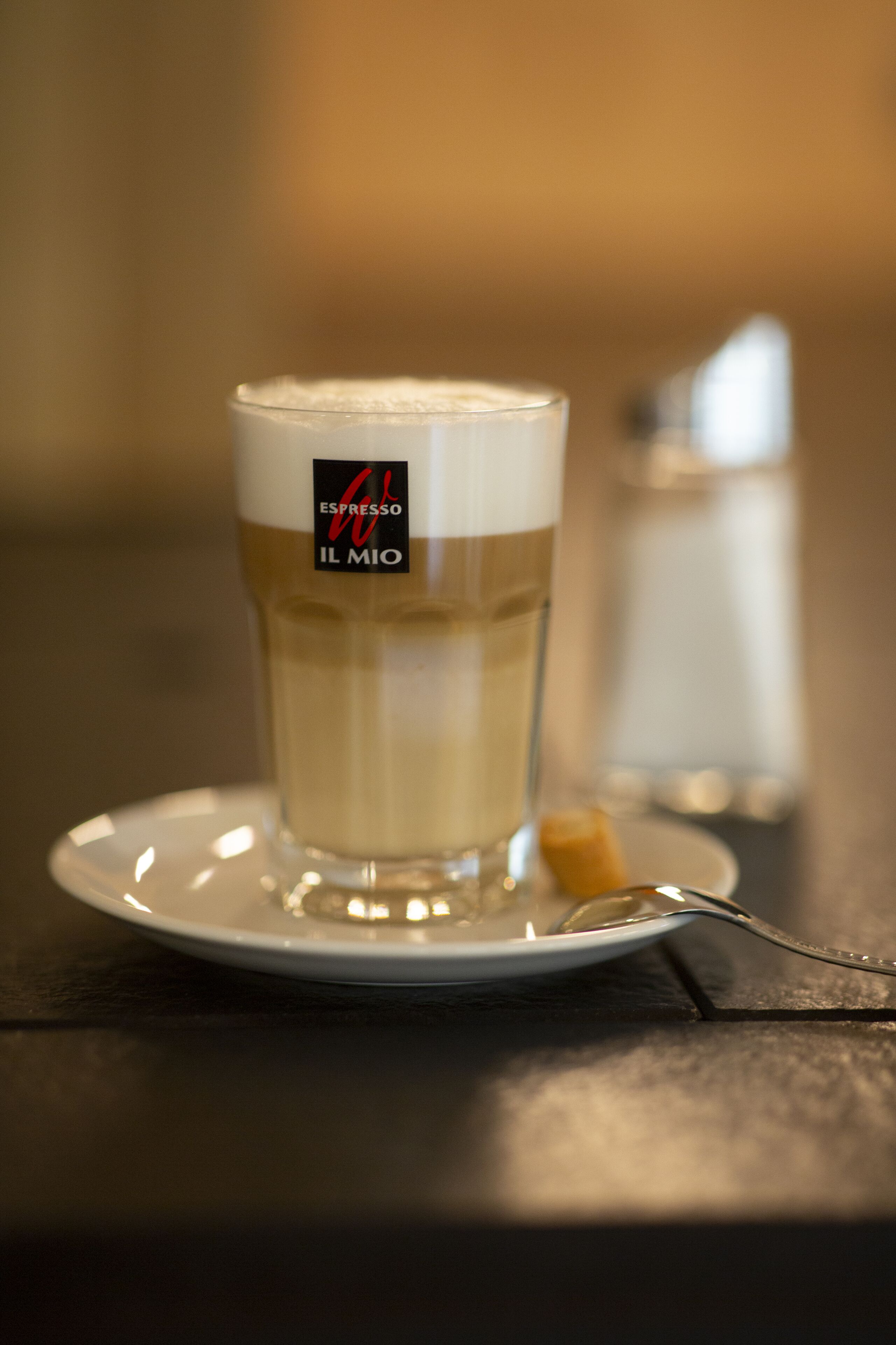 Een glas bier met een etiket op een schotel.