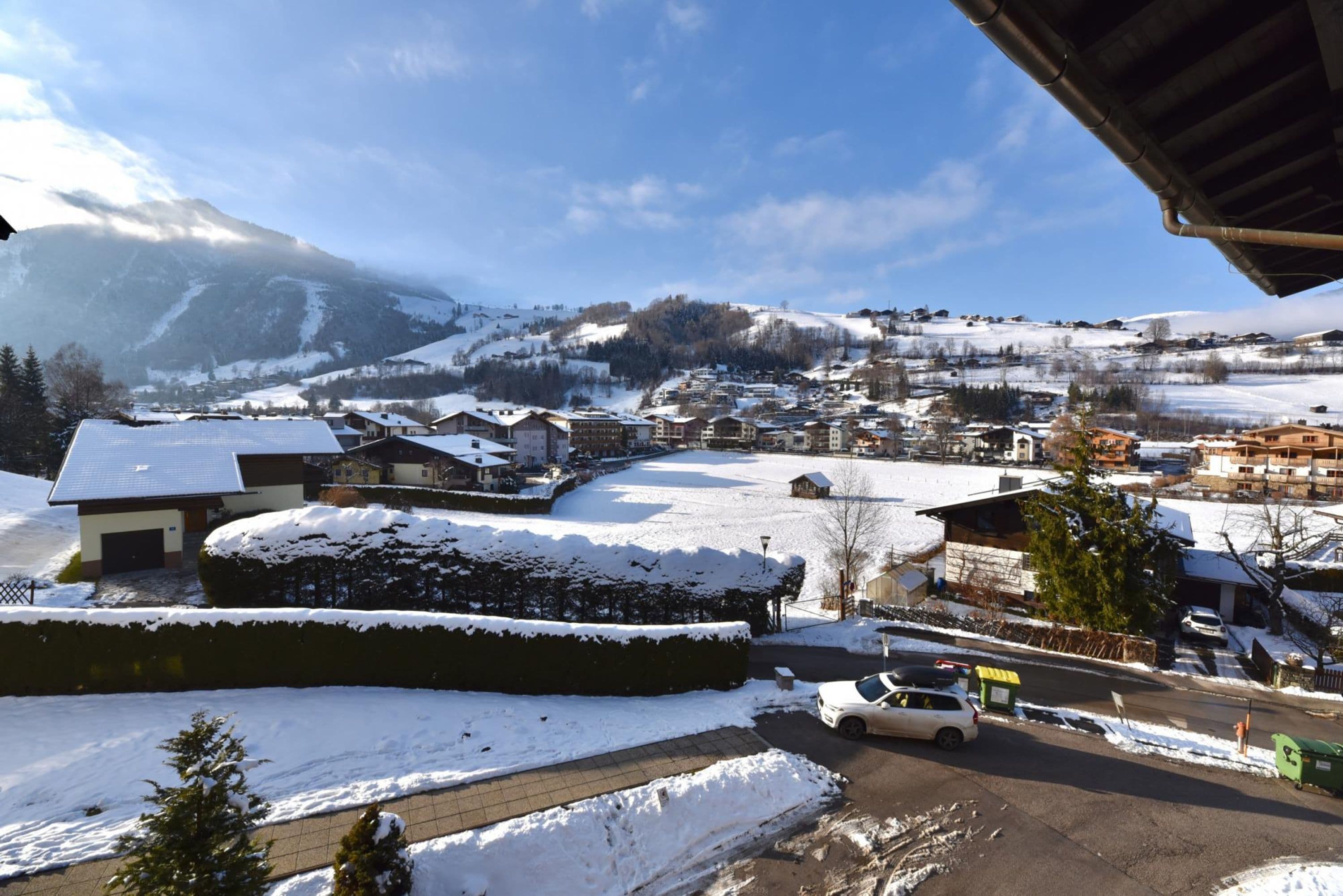 Ein schneebedecktes Dorf mit Häusern und einer Straße.