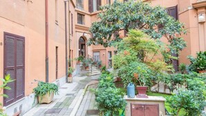 A narrow courtyard with a central staircase surrounded by buildings with shutters. - La Casa dell'Arte by Interhome (Rome: Historical City Center)