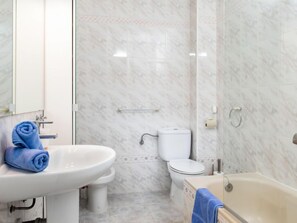 Un baño con lavamanos, inodoro y bañera.