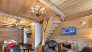 A cozy wooden interior with a dining area, kitchen, and seating space. - Bright duplex for 8 people, near center, Méribel (Méribel)