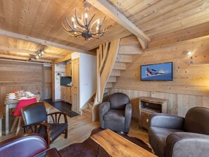 A cozy wooden interior with a dining area, kitchen, and seating space.